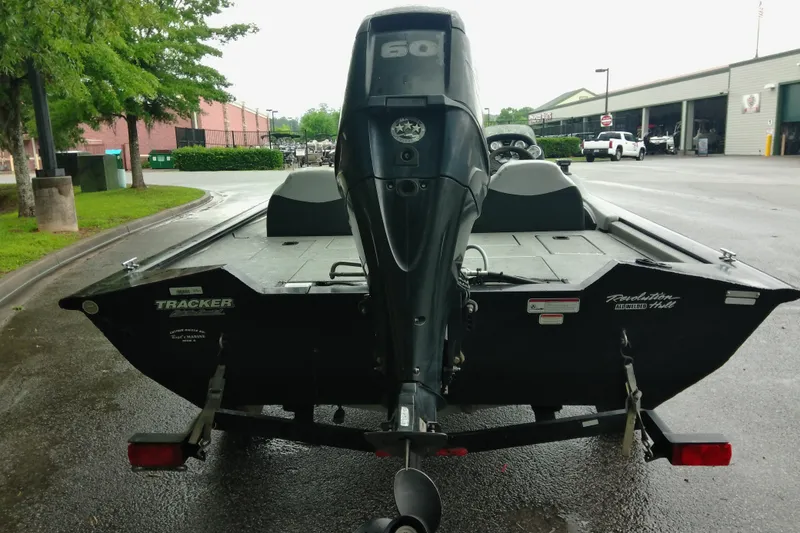 Slide: The Image of 2016 Tracker Pro Team 175 TXW boat with outboard motor, parked outdoors on wet pavement. - 8