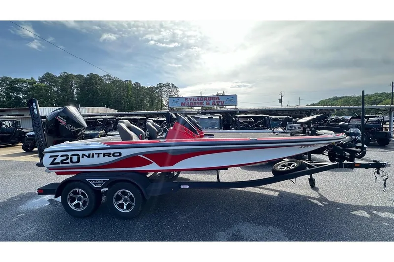 The Image of 2023 Nitro Z20 Pro boat on trailer at dealership, under cloudy sky. - 0