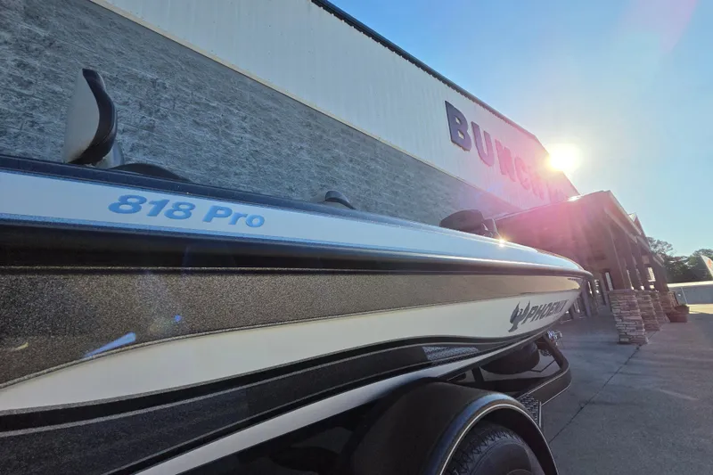 Slide: The Image of 2026 Phoenix 818 Pro boat parked outside a building under bright sunlight. - 12