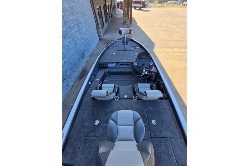 Slide: The Image of 2026 Phoenix 818 Pro boat interior with seating and steering console, parked outdoors. - 6