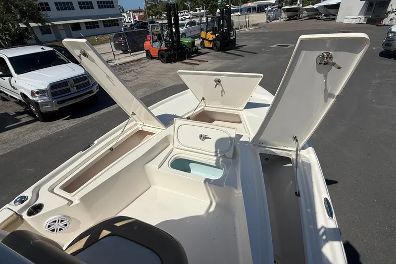 Slide: The Image of 2015 Key West 210 Bay Reef boat with open storage compartments in a marina setting. - 18