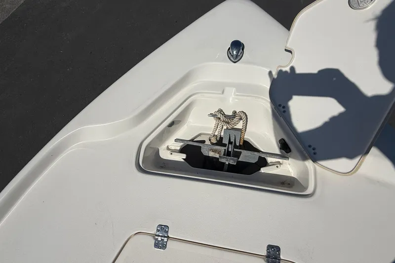 Slide: The Image of 2015 Key West 210 Bay Reef boat anchor compartment with open hatch and visible rope. - 20