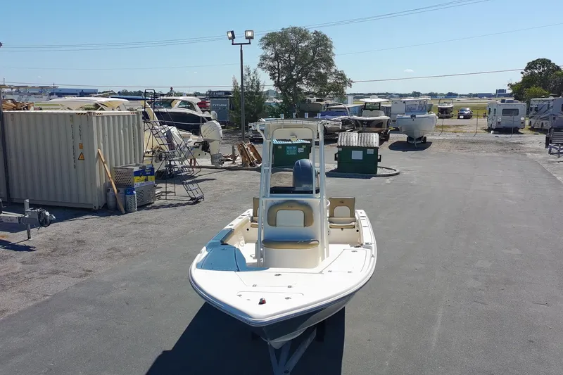 Slide: The Image of 2015 Key West 210 Bay Reef boat in a storage yard under clear blue sky. - 6