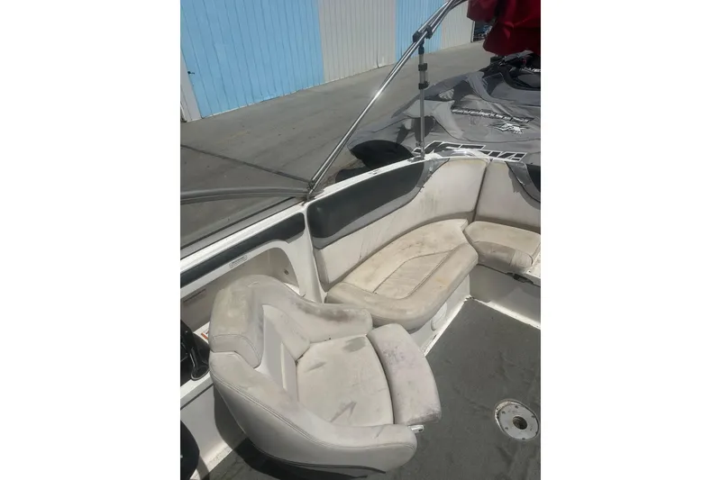 Slide: The Image of 2008 Yamaha Boats SX230 interior with seating and steering wheel, docked near blue building. - 11