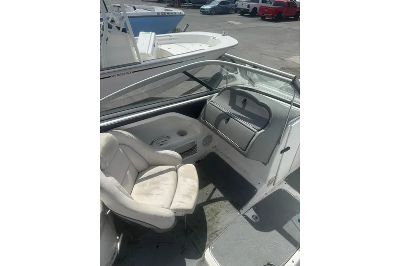 Slide: The Image of 2008 Yamaha Boats SX230 interior with seating and dashboard, parked in a marina. - 13