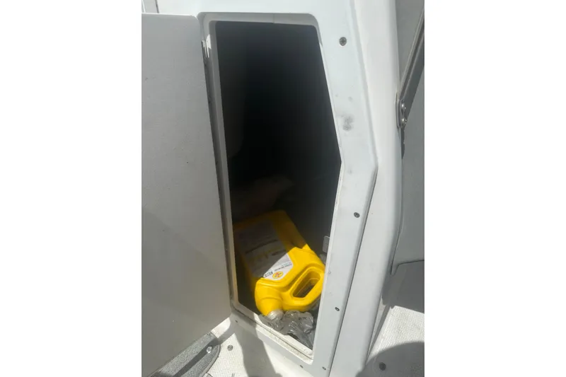 Slide: The Image of Storage compartment on a 2008 Yamaha Boats SX230, containing a yellow container. - 15