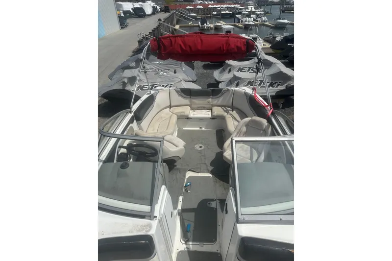 Slide: The Image of 2008 Yamaha Boats SX230 interior with seating, docked near jet skis. - 17
