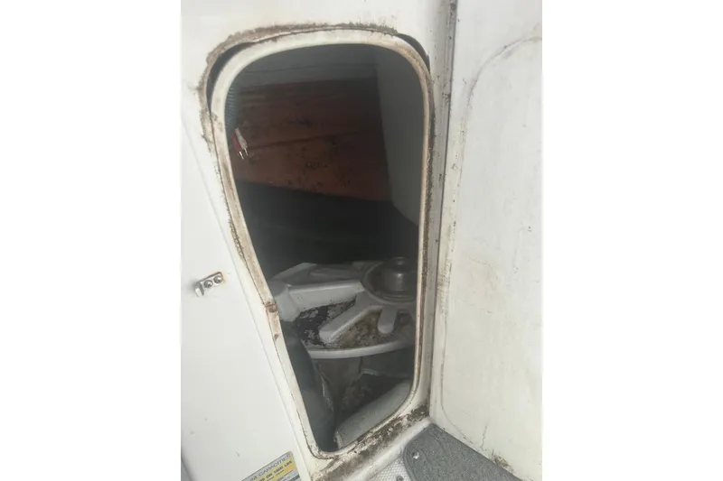 Slide: The Image of 2008 Yamaha Boats SX230 storage compartment with visible wear and equipment inside. - 18