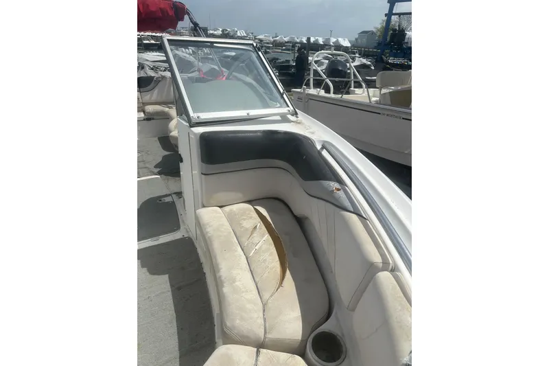 Slide: The Image of 2008 Yamaha Boats SX230 interior with worn seating and cup holder, docked at marina. - 19