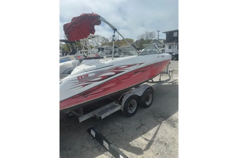 Slide: The Image of 2008 Yamaha Boats SX230 on trailer, red and white design, parked outdoors. - 3