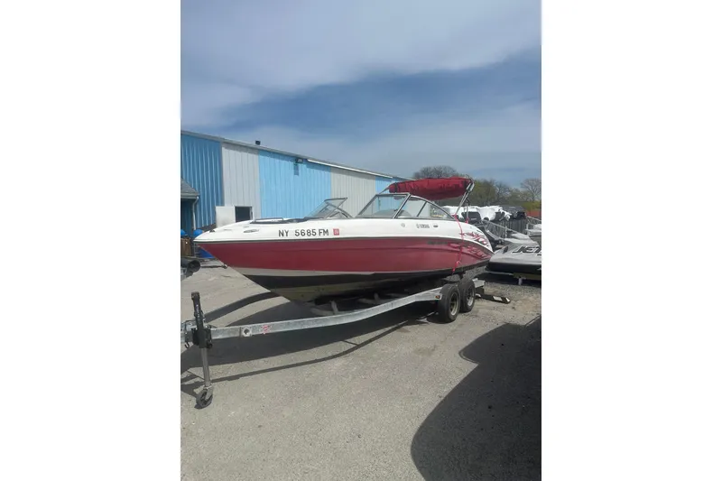 Slide: The Image of 2008 Yamaha Boats SX230 on trailer, parked outdoors near blue building. - 4