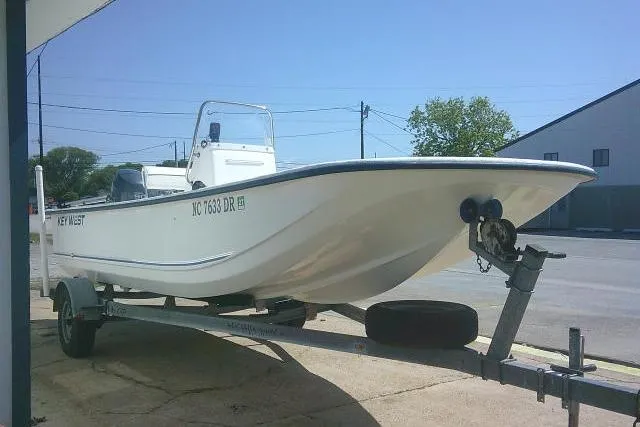 Slide: The Image of 2010 Key West 197 Skiff boat on trailer, parked outdoors under clear blue sky. - 4