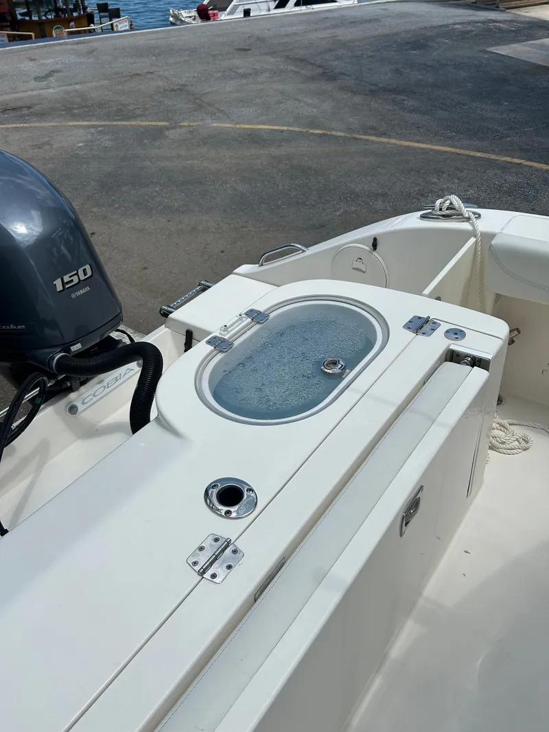 Slide: The Image of 2022 Cobia 262 Center Console with outboard motor at dock. - 32