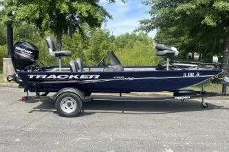 Slide: The Image of 2019 Tracker Pro 170 boat on trailer, parked outdoors with trees in the background. - 3