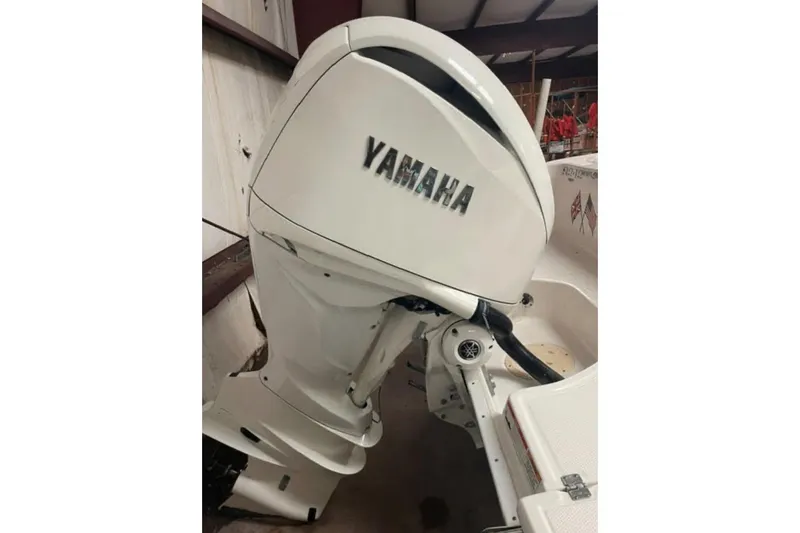 Slide: The Image of 2023 Robalo R242 Explorer with Yamaha outboard motor in a showroom setting. - 2