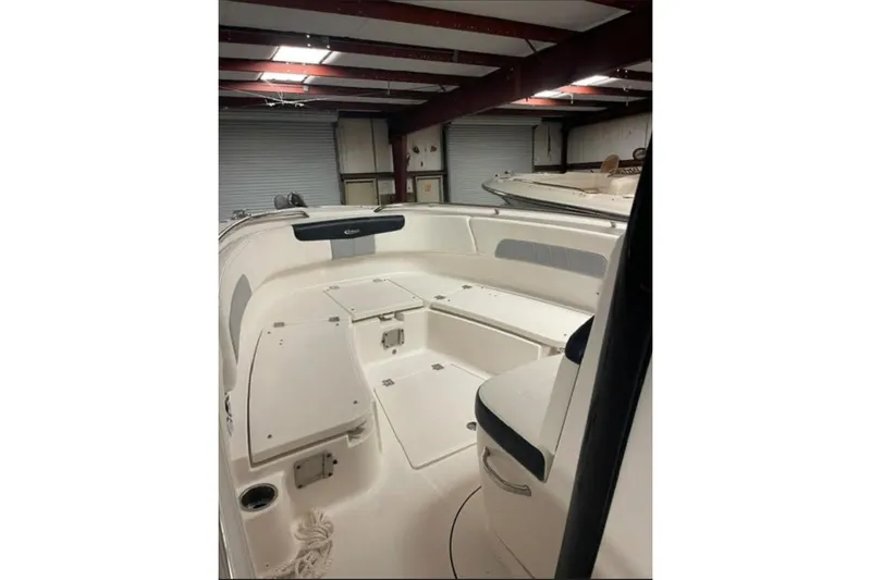 Slide: The Image of 2023 Robalo R242 Explorer boat interior in storage, featuring seating and storage compartments. - 5