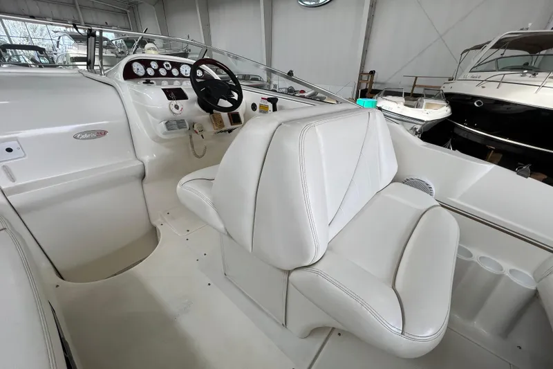 Slide: The Image of 2002 Larson Cabrio 254 boat interior with white seating and control panel. - 10