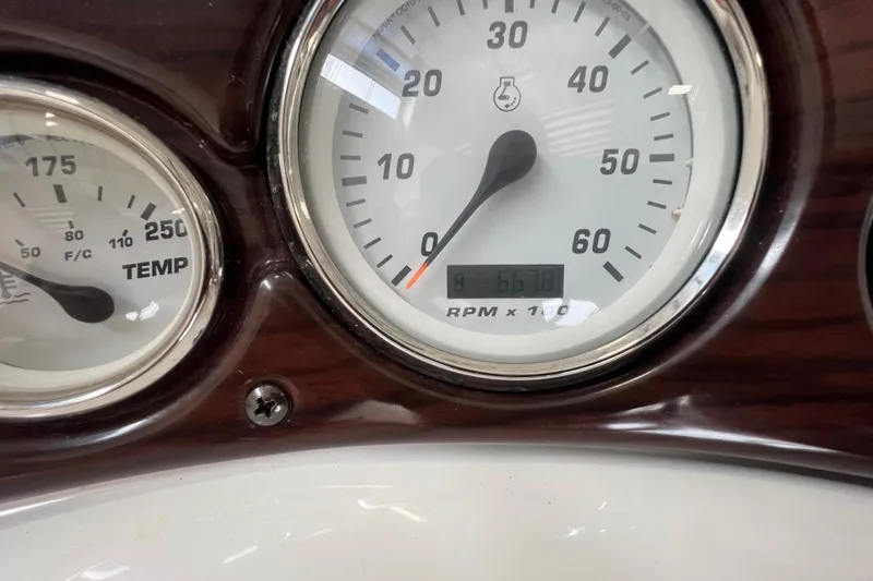 Slide: The Image of Close-up of 2002 Larson Cabrio 254 boat gauges, showing RPM and temperature. - 12