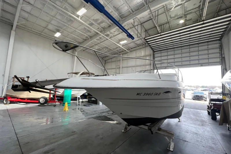 Slide: The Image of 2002 Larson Cabrio 254 boat in a spacious indoor storage facility. - 2