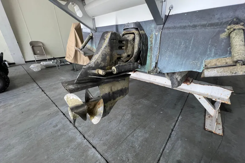 Slide: The Image of 2002 Larson Cabrio 254 boat propeller and stern drive in a garage setting. - 5