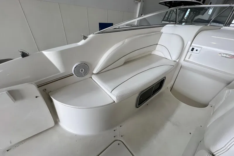 Slide: The Image of 2002 Larson Cabrio 254 boat interior with white seating and speaker. - 8