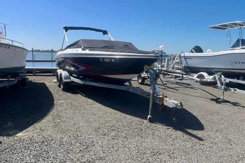 The Image of 2013 Larson LSR 2300 I/O boat on trailer, parked near waterfront. - 0