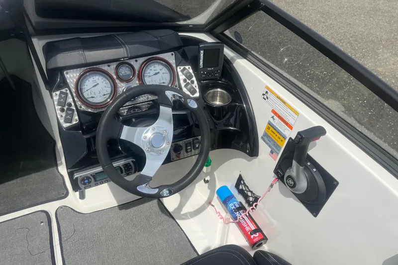 Slide: The Image of Cockpit of 2013 Larson LSR 2300 I/O boat with steering wheel and control panel. - 10