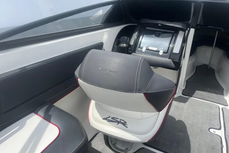 Slide: The Image of Interior of a 2013 Larson LSR 2300 I/O boat, featuring sleek seating and modern dashboard. - 9