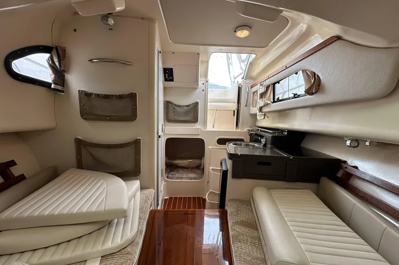 Slide: The Image of Interior of 2006 Grady-White Sailfish 282 boat, featuring seating, storage, and kitchenette. - 10