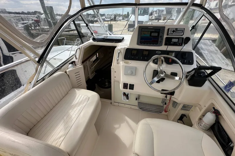 Slide: The Image of 2006 Grady-White Sailfish 282 boat cockpit with steering wheel and navigation equipment. - 11