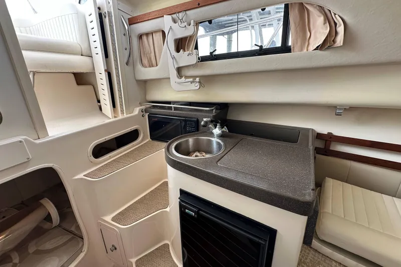 Slide: The Image of 2006 Grady-White Sailfish 282 cabin interior with kitchenette, sink, and seating area. - 13