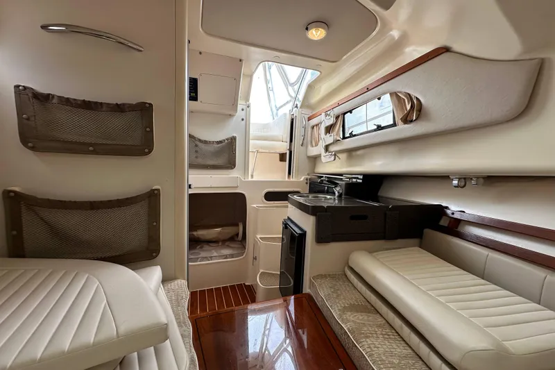 Slide: The Image of 2006 Grady-White Sailfish 282 cabin interior with seating, kitchenette, and storage. - 19