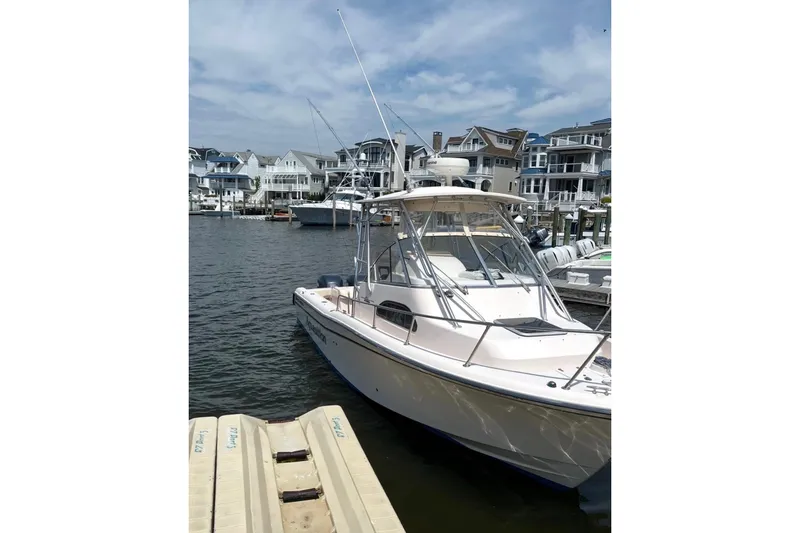 Slide: The Image of 2006 Grady-White Sailfish 282 boat docked in a marina with waterfront homes. - 2
