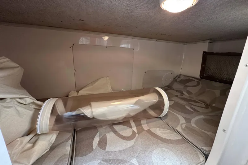 Slide: The Image of 2006 Grady-White Sailfish 282 cabin interior with patterned cushions and storage space. - 20