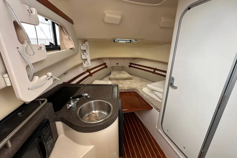 Slide: The Image of 2006 Grady-White Sailfish 282 cabin interior with kitchenette and sleeping area. - 9