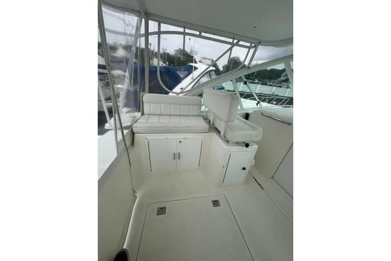Slide: The Image of 2008 Cabo 32 Express boat interior with white seating and storage compartments. - 10