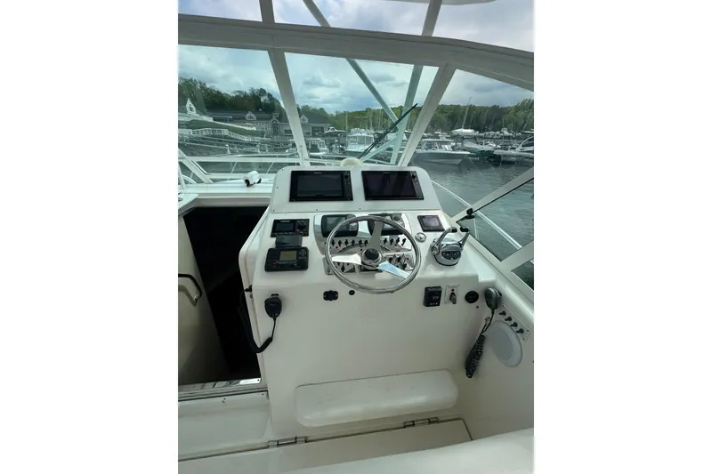 Slide: The Image of Helm of 2008 Cabo 32 Express boat with steering wheel and navigation controls. - 13