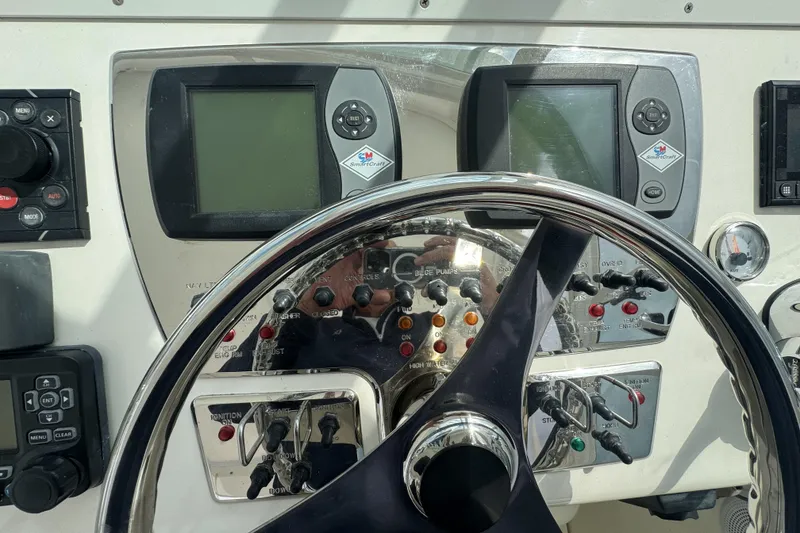 Slide: The Image of Control panel of a 2008 Cabo 32 Express boat with steering wheel and navigation displays. - 18