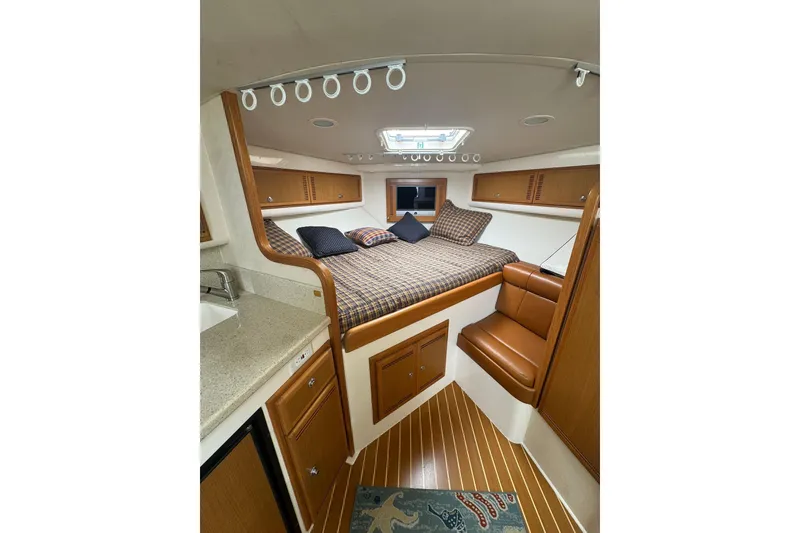 Slide: The Image of Interior of 2008 Cabo 32 Express boat with cozy bed and wooden cabinetry. - 21
