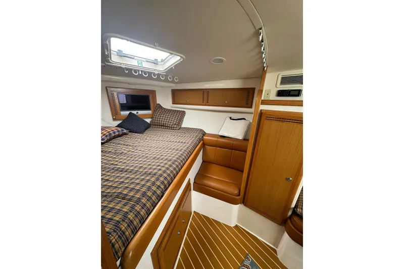 Slide: The Image of Interior of 2008 Cabo 32 Express boat with cozy bed and wooden cabinetry. - 22