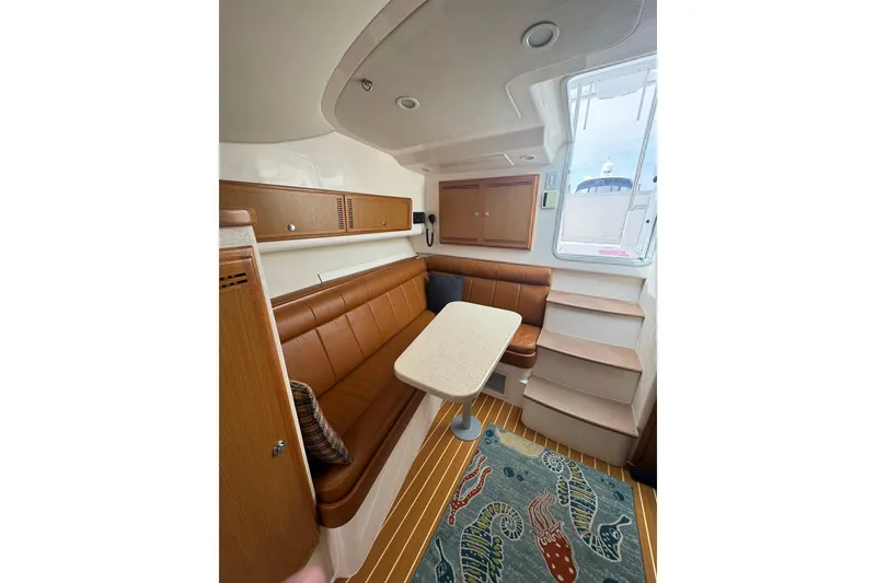 Slide: The Image of Interior of 2008 Cabo 32 Express boat with seating, table, and stairs. - 24