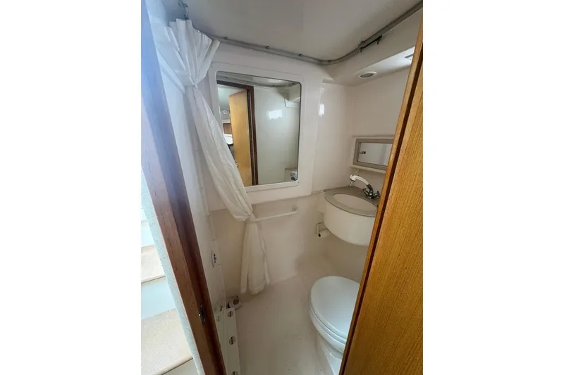 Slide: The Image of Compact bathroom in 2008 Cabo 32 Express boat, featuring sink, toilet, and mirror. - 27