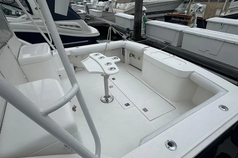 Slide: The Image of 2008 Cabo 32 Express boat interior with seating and fishing rod holders at a marina. - 7