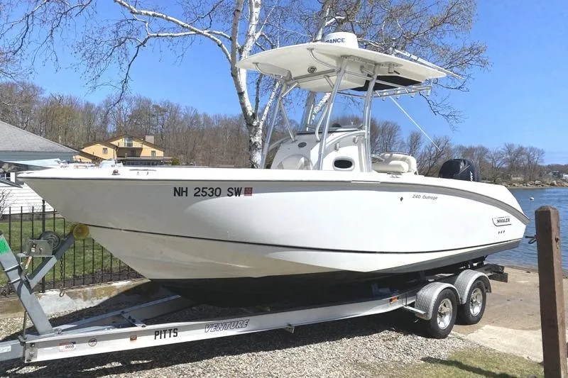 The Image of 2007 Boston Whaler 240 Outrage boat on trailer by lakeside, ready for adventure. - 0
