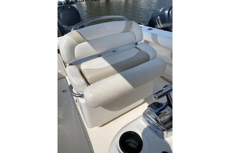 Slide: The Image of Boston Whaler 240 Outrage 2007 boat seat with white upholstery and chrome accents. - 12