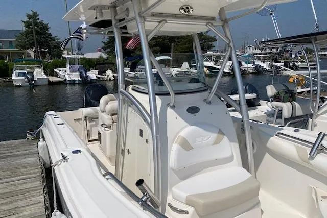 Slide: The Image of 2007 Boston Whaler 240 Outrage docked at marina, featuring sleek design and spacious seating. - 8