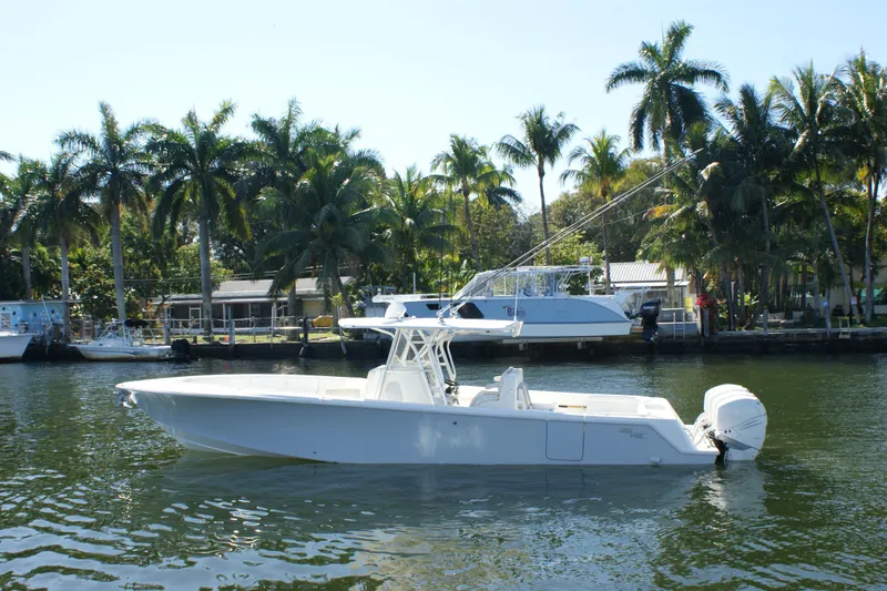 The Image of 2018 SeaVee 390Z boat on calm water, surrounded by palm trees. - 1