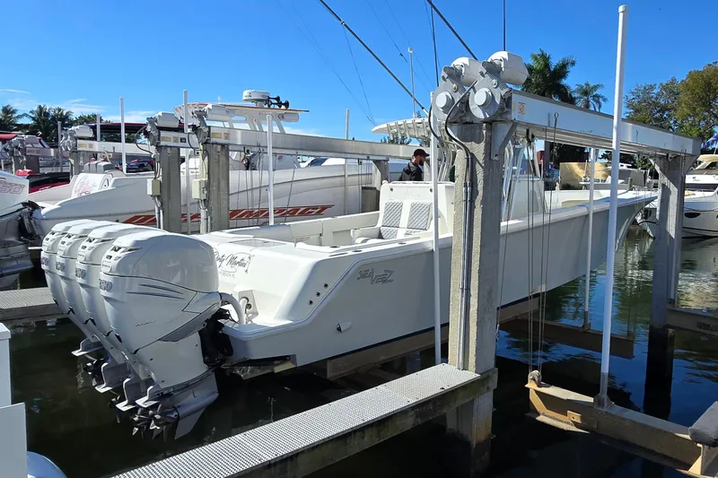 Slide: The Image of 2018 SeaVee 390Z boat with triple outboard engines on a lift at a marina. - 4