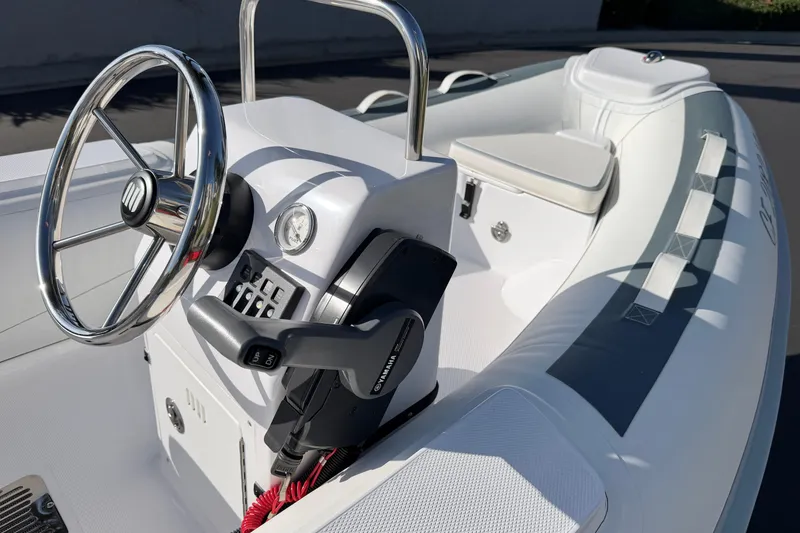 Slide: The Image of 2021 Novurania Deluxe 335 boat interior with steering wheel and control panel. - 12