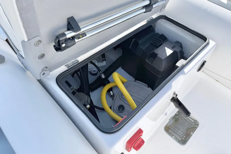 Slide: The Image of Open storage compartment in 2021 Novurania Deluxe 335 boat, showing equipment and wiring. - 13